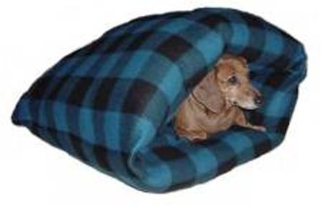 A cute dog tucked cozily inside Rita's Burrow Bed